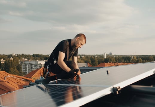 Technician working on solar panel on rooftop